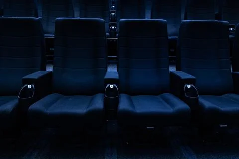 Empty dark rows of blue cinema seats in auditorium 스톡 사진