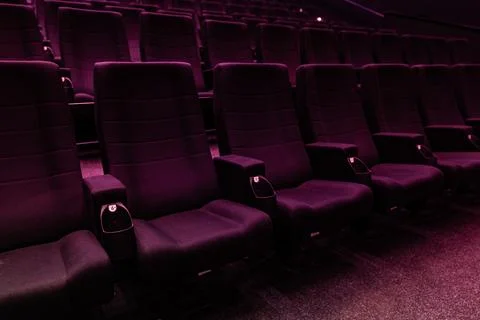 Empty dark rows of purple cinema seats in movie theater 스톡 사진