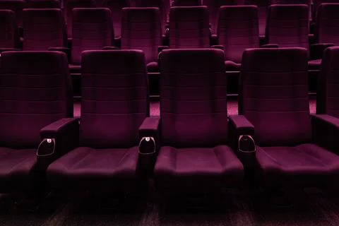 Empty dark rows of purple cinema seats in movie theater 스톡 사진