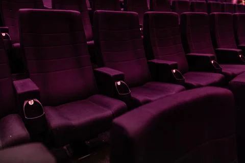 Empty dark rows of purple cinema seats in movie theater 스톡 사진