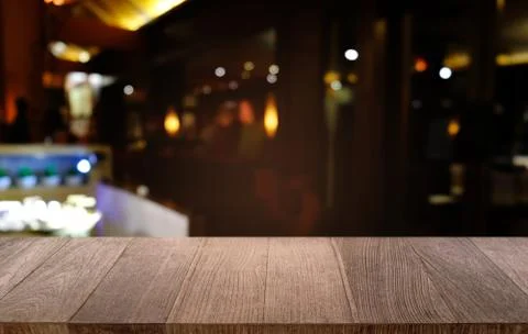 Empty dark wooden table in front of abstract blurred bokeh background of rest Stock Photos