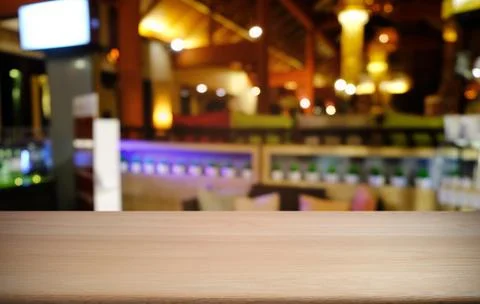 Empty dark wooden table in front of abstract blurred bokeh background of rest Stock Photos