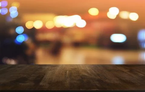 Empty dark wooden table in front of abstract blurred bokeh background of rest Stock Photos