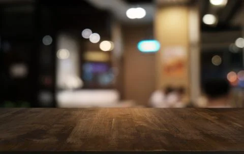 Empty dark wooden table in front of abstract blurred bokeh background of rest Stock Photos