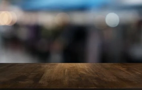 Empty dark wooden table in front of abstract blurred bokeh background of rest Stock Photos