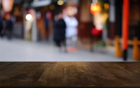 Empty dark wooden table in front of abstract blurred bokeh background of rest Stock Photos