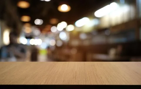 Empty dark wooden table in front of abstract blurred bokeh background of rest Stock Photos
