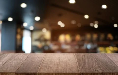 Empty dark wooden table in front of abstract blurred bokeh background of rest Stock Photos