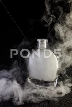Empty decanter with smoke on black background Stock Photos
