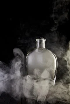 Empty decanter with smoke on black background Stock Photos