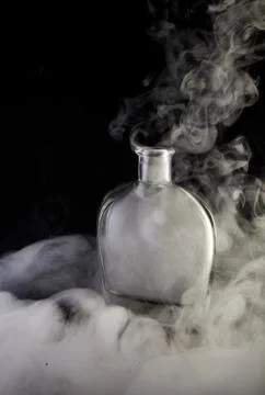 Empty decanter with smoke on black background Stock Photos