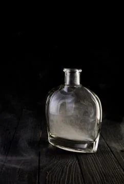Empty decanter with smoke on black background Stock Photos
