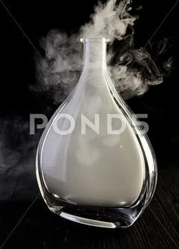 Empty decanter with smoke on black background Stock Photos