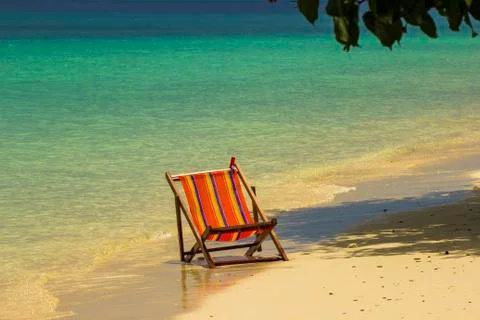 Empty deck chair on a sandy beach Stock Photos