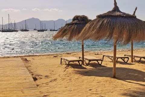 Empty deck chairs and umbrellas on the beach in Port de Pollenca, Mallorca Stock Photos