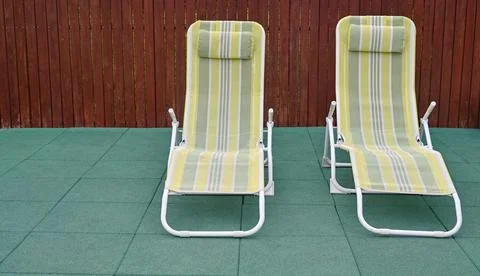 Empty deck chairs in the backyard. Stock Photos