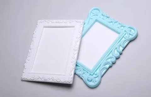 Empty decorative photo frames with ornate designs on grey background Stock Photos