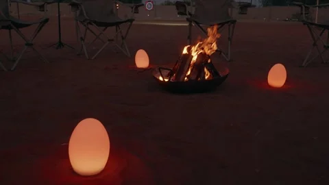 Empty desert camp with campfire and chairs at dusk, travel background Stock Footage 327896455