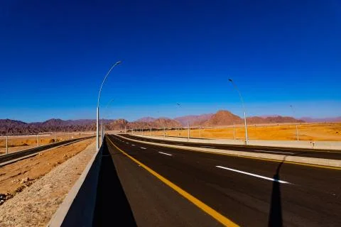 Empty desert road in Egypt with clear blue sky Stock Photos