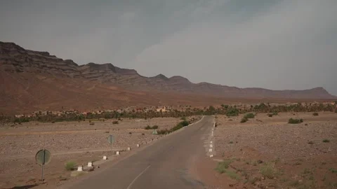 Empty Desert Road Leading to a Palm Oasis Village in Morocco Stock Footage 340595892