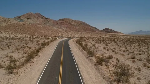 Empty desert road with mountain background - drone flying forward Video stock 107879560