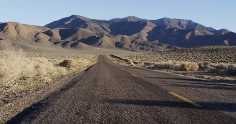 Empty desert road with mountains on a sunny day Stock Footage 107626861
