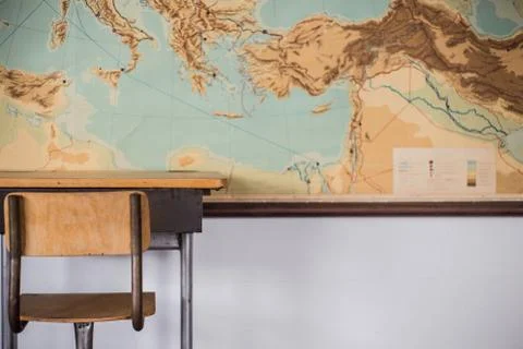 Empty desks at school classroom with world map. Stock Photos