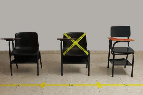 Empty desks spaced one meter apart marked with yellow tape and distance marki Foto stock