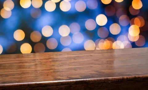 Empty diagonal dark wood table with blur night lights in blue sky bokeh backg Stock Photos