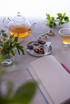 Empty diary, pen, tea and flowers on table Stock Photos