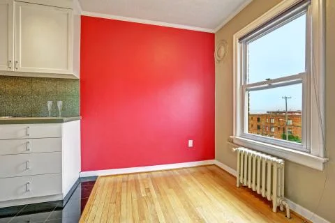 Empty dining area with bright red wall and window Stock Photos