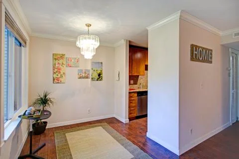 Empty dining area with light walls and hardwood floor. Stock Photos
