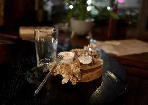 An Empty Dining Plate that has Leftover Food and Beverages Resting on a Table Foto stock