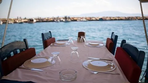 Empty dining table by the sea. blue seaside restaurant Stock Photos