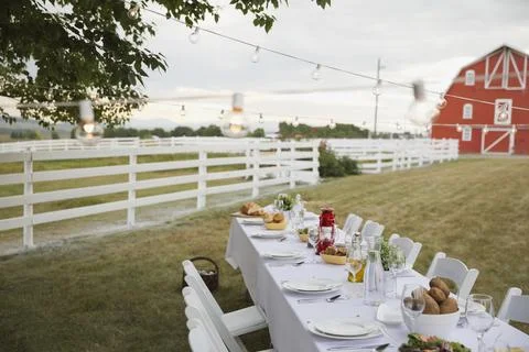 Empty dining table set up outdoors on farm Stock Photos