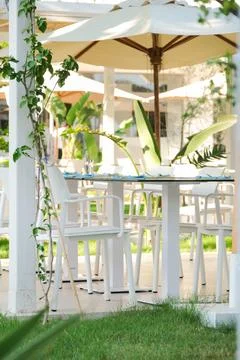 Empty dining tables and chairs outdoors in the hotel terrace Stock Photos