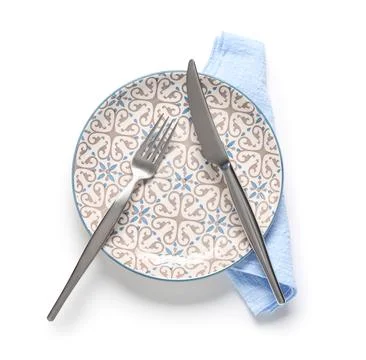 Empty dinner plate with ornate pattern, fork, knife, and blue napkin, isolate Stock Photos