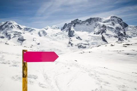Empty directional sign post with winter snow mountain landscape. 库存照片