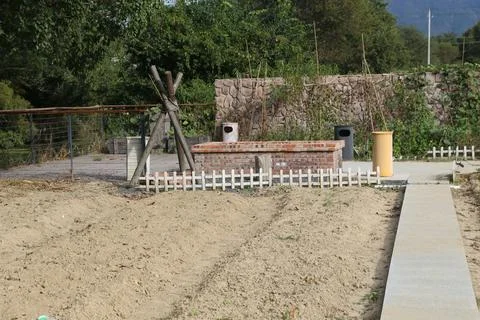 Empty dirt garden plot with brick planter and white picket fence in rural s.. 写真素材