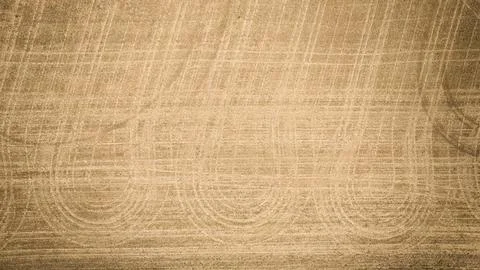 Empty dirt plowed tilled fields tractor lines visible in ruts in ground aerial Foto stock