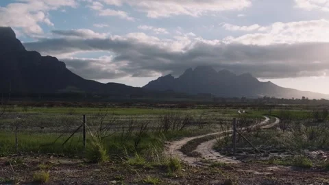 Empty dirt road in a mountaineous valley at sunset, Slow Motion Pan 4K Video stock 335314010