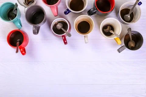 Empty dirty coffee cups of different colors on the table. Concept of caffeine Stock Photos