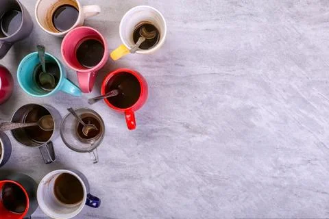 Empty dirty coffee cups of different colors on the table. Concept of caffeine Stock Photos