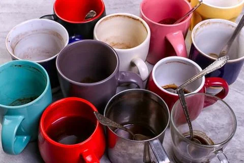 Empty dirty coffee cups of different colors on the table. Concept of caffeine Stock Photos