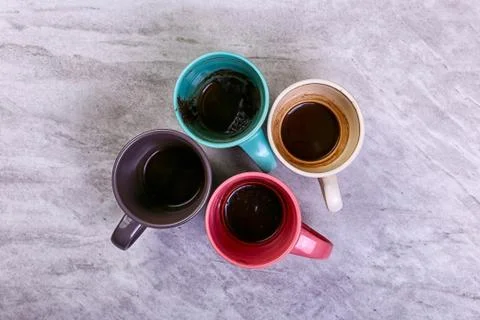 Empty dirty coffee cups of different colors on the table. Concept of caffeine Stock Photos