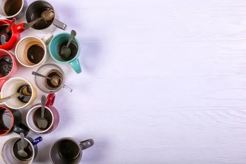 Empty dirty coffee cups of different colors on the table. Concept of caffeine Stock Photos