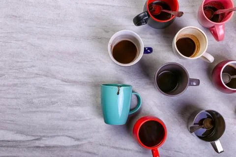 Empty dirty coffee cups of different colors on the table. Concept of caffeine Stock Photos