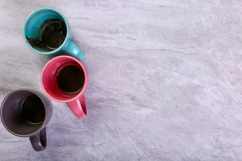 Empty dirty coffee cups of different colors on the table. Concept of caffeine Stock Photos