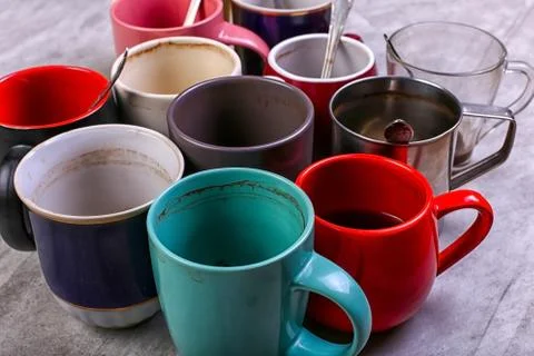 Empty dirty coffee cups of different colors on the table. Concept of caffeine Stock Photos
