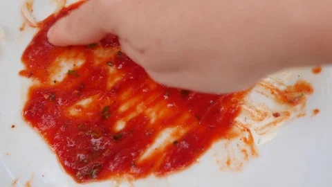 Empty dirty plates with the remains of ketchup. Men's hands paint an evil smile Stock Footage